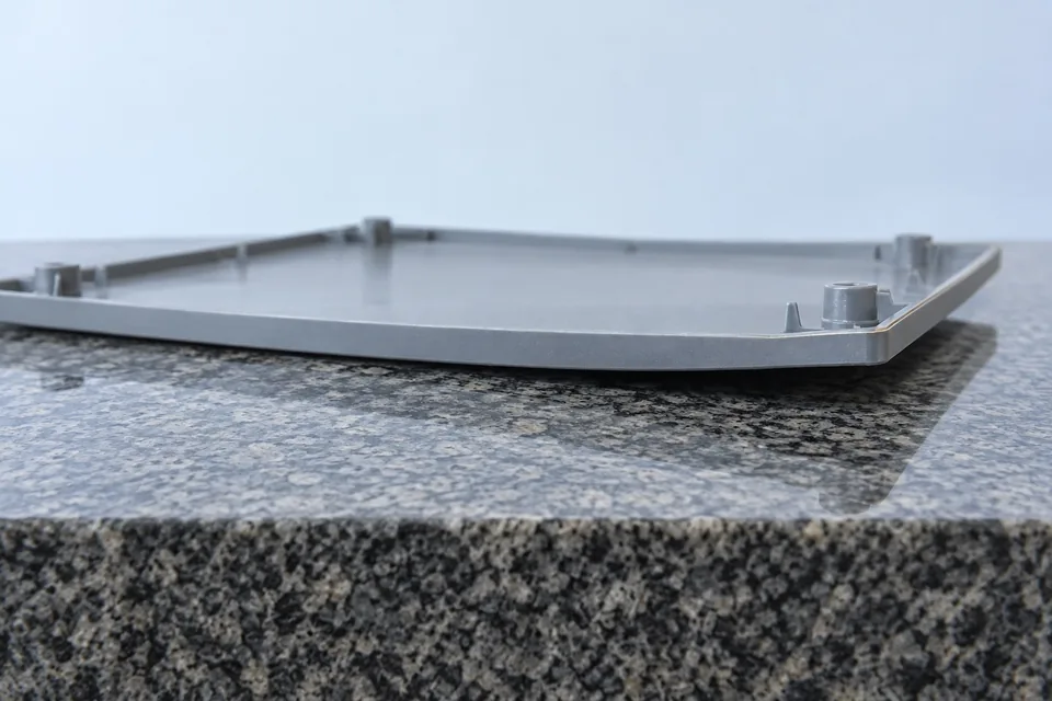 Gebogene geformte Abdeckung über einer flachen Inspektionsfläche aus Granit – Abbildung