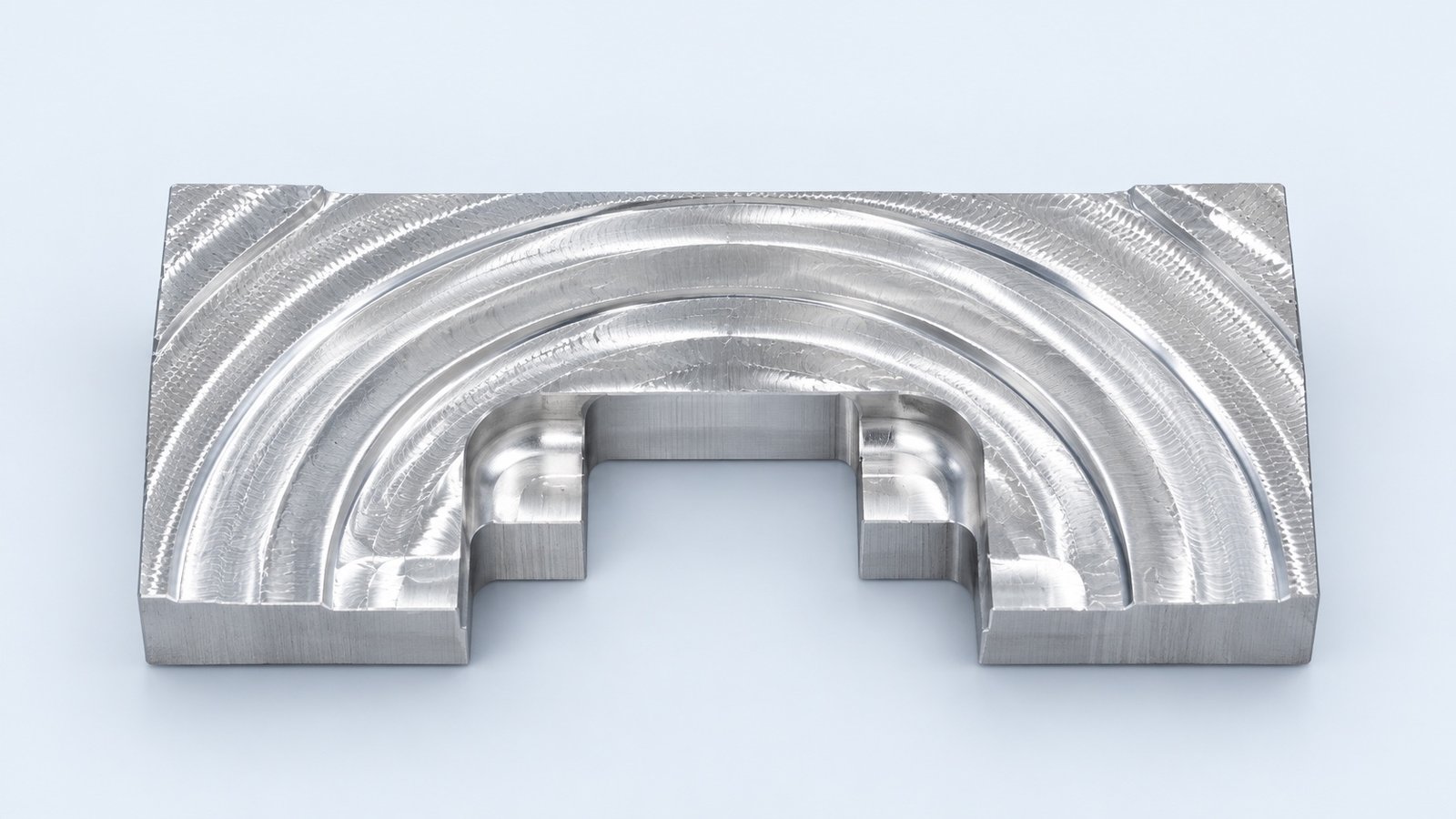 Studio-retouched company photograph of a contoured machined surface sample