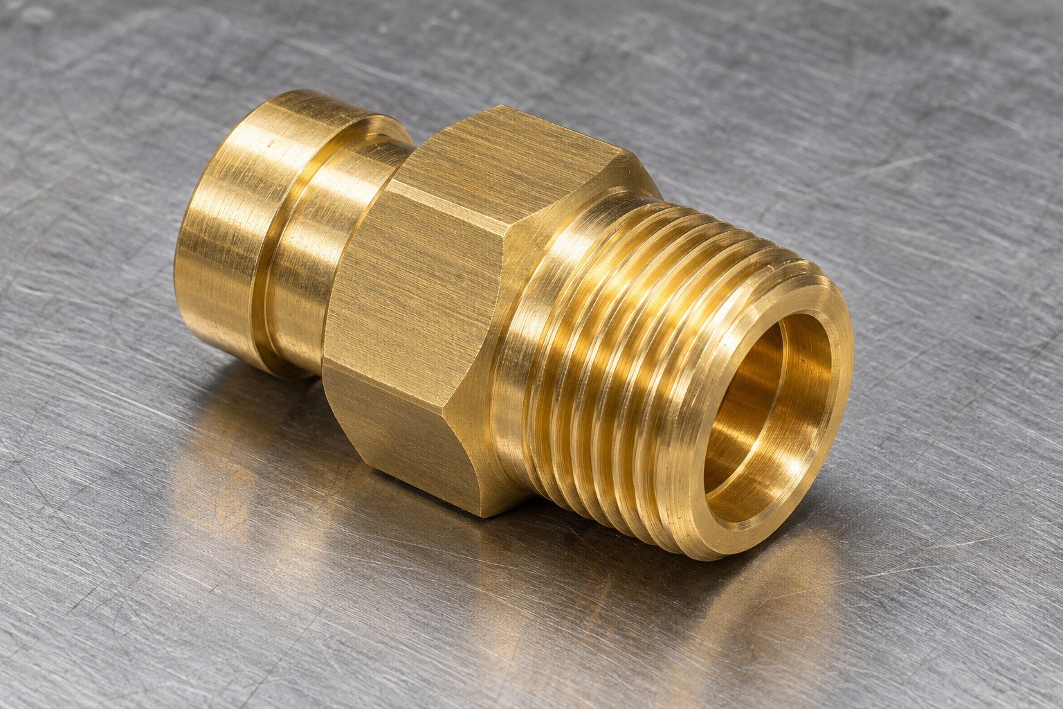 Studio industrial macro product photo of a single yellow gold brass hexagonal threaded fitting with shoulder and stepped flow bore — illustrative generated component concept