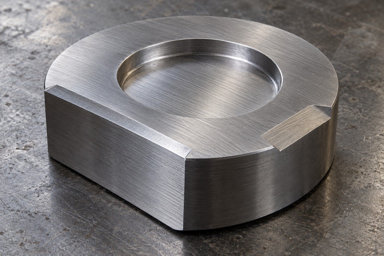 Thick round tooling coupon with unequal milled flats and shallow broad recess, fine linear grinding texture, grey steel. — illustrative generated component concept
